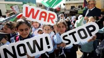 Palestinian protesters hold placards during a protest called by the Fatah movement in Nablus, the West Bank. 26 October 2023. | Ayman Nobani/dpa/picture-alliance/Newscom