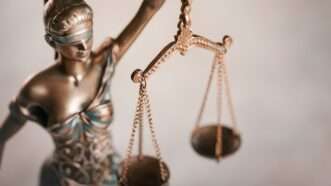 Close-up of a statue of blindfolded Lady Justice, with focus on the scales she is holding. | Oleg Dudko | Dreamstime.com