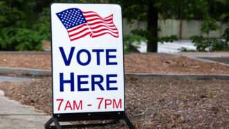 A sign for a polling place that reads VOTE HERE 7AM-7PM | Carol Hudson | Dreamstime.com