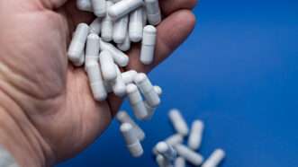 An outstretched hand opens, spilling out numerous unidentified pill capsules. | Milcho Milev | Dreamstime.com