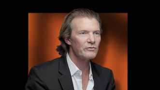 Johan Norberg in front of orange square background | Lex Villena